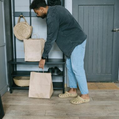 Person arranging shopping bags in a stylish apartment hallway.